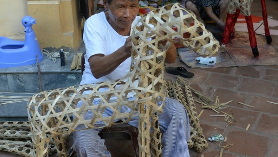 Fabrication d'un cheval en papier dans un atelier de Hanoï, le 8 août 2016