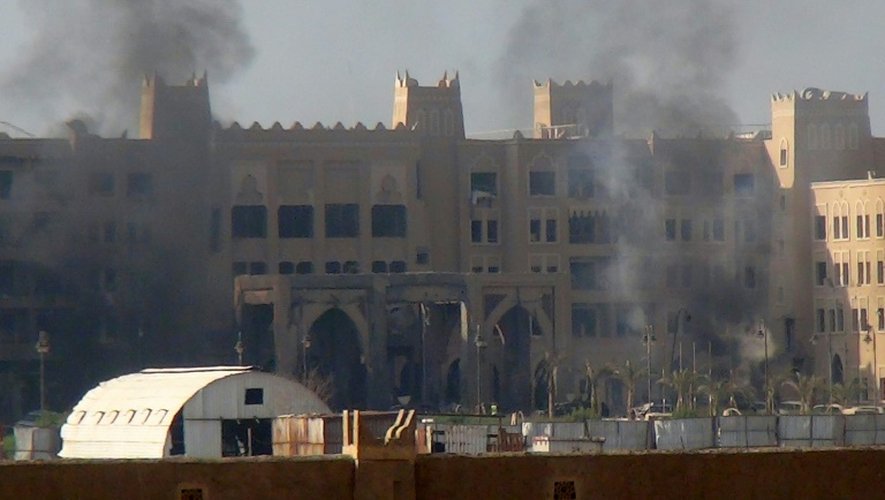 De la fumée s'élève de l'hôtel Al-Qasr, où logeait le Premier ministre yéménite, après un attaque à la roquette, le 6 octobre 2015 à Aden