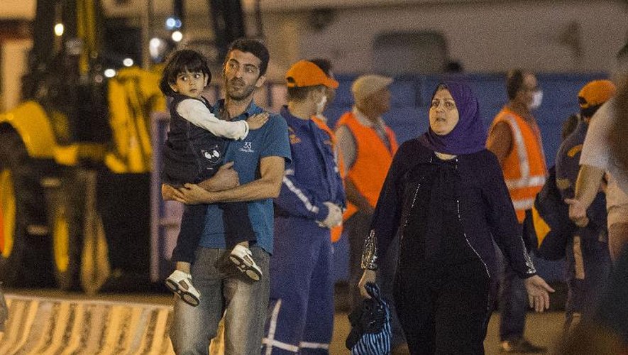 Des réfugiés syriens débarquent du bateau qui les a secourus le 25 septembre 2014 dans le port de Limassol