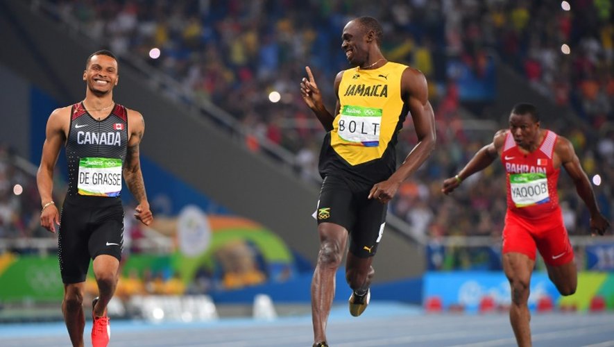 Usain Bolt échange avec le Canadien Andre de Grasse à l'arrivée de leur demi-finale du 200 m aux Jeux de Rio, le 17 août 2016