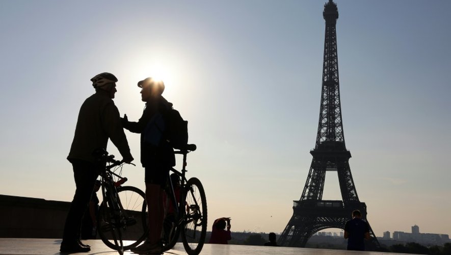 Deux cyclistes discutent devant la tour Eiffel avant de participer à la "journée sans voiture" organisée par la mairie de Paris, le 27 septembre 2015