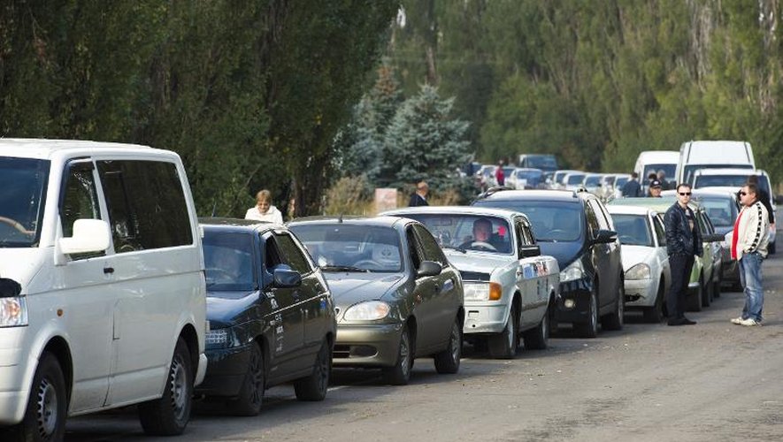 Des automobilistes patientent au poste frontière d'Ouspenka, en Ukraine, le 26 septembre 2014