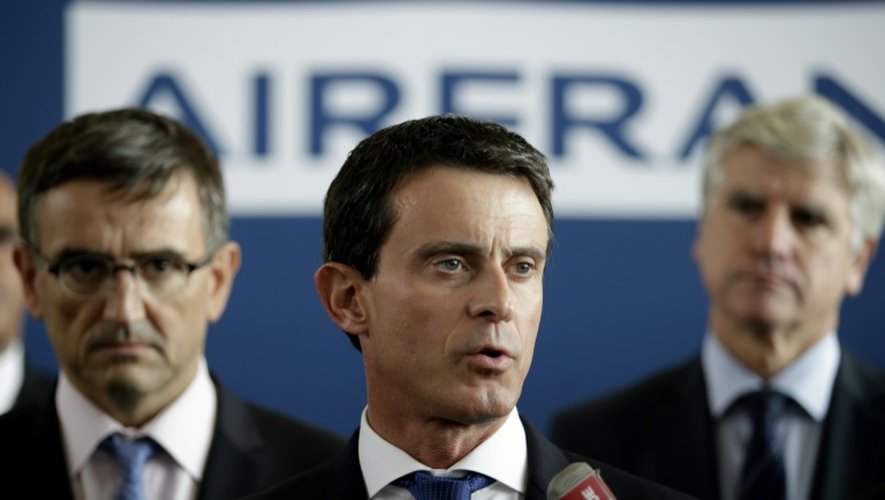 Le Premier ministre Manuel Valls (c) en conférence de presse au côté du DRH adjoint d'Air France Xavier Broseta (g) et du directeur long-courriers Pierre Plissonnier (d) le 6 octobre 2015 à Roissy-en-France