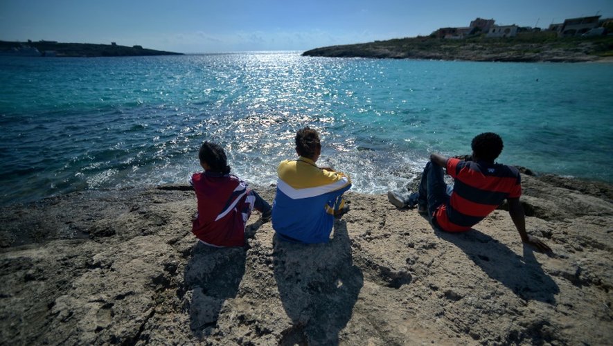 De jeunes migrants regardent la mer depuis l'île de Lampedusa
