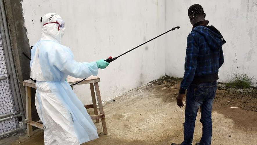 Un visiteur est décontaminé à son arrivée à l'hôpital Island à Monrovia (Libéria) où il est venu apporter de la nourriture à des proches souffrant du virus Ebola, le 26 septembre 2014