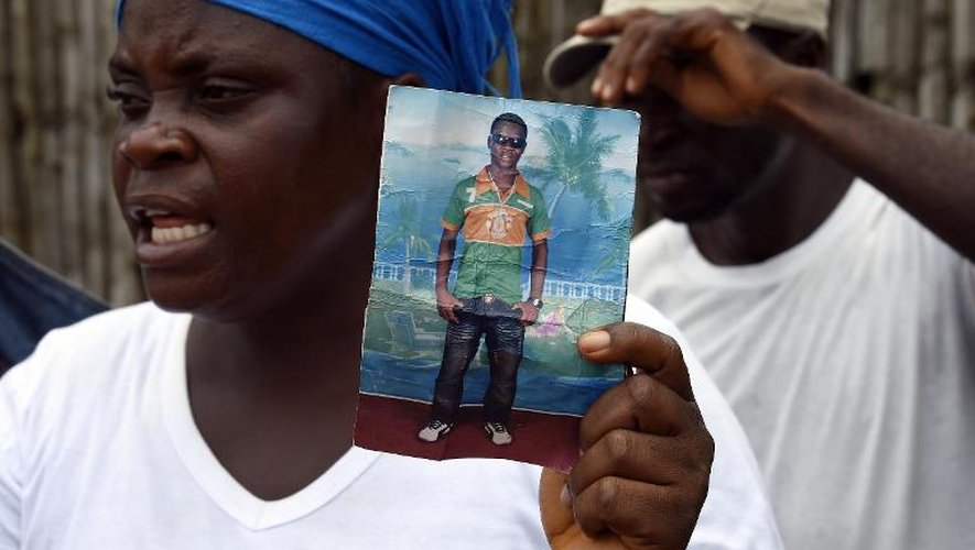 Une mère libérienne tient une photo de son fils Emaya, âgé de 20 ans, soigné contre le virus Ebola dans l'hôpital Island à Monrovia (Libéria) mais dont elle est sans nouvelles, le 26 septembre 2014