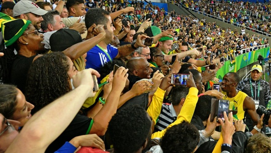 Les fans d'Usain Bolt (à d.) le félicitent après sa victoire au 200m à Rio le 18 août 2016
