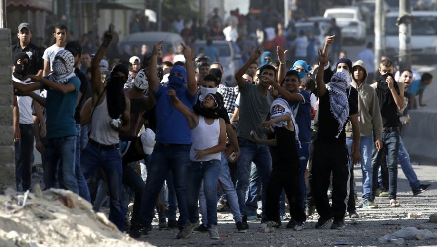 Des Palestiniens s'opposent aux forces de sécurité israélienne à un point de passage à Qalandia en Cisjordanie le 6 octobre 2015