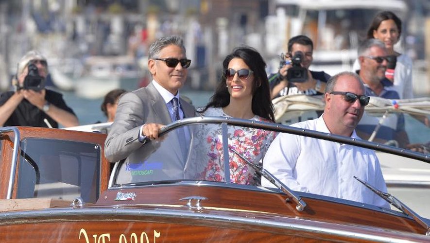George Clooney (gauche) et sa femme Amal Alamuddin sur un bateau à Venise le 28 septembre 2014