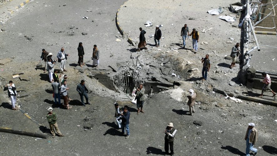 Des habitants autour d'un cratère provoqué par une frappe aérienne de la coalition arabe, le 1er octobre 2015 à Sanaa, au Yémen