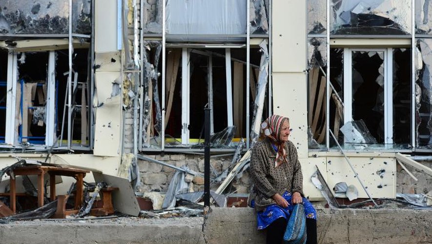 Une femme âgée devant un bâtiment détruit à Pervomaisk, dans l'est de l'Ukraine, le 28 septembre 2014