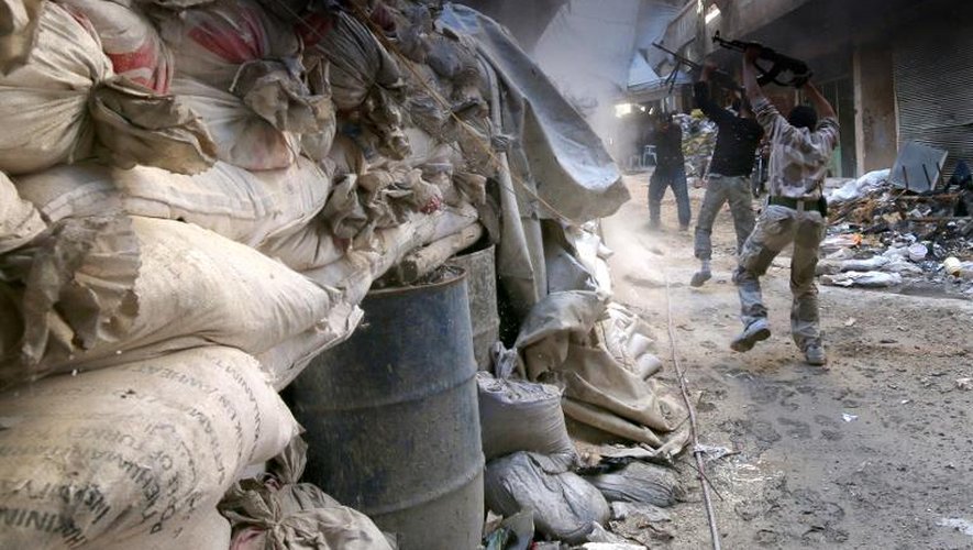 Des rebelles tirent près de sacs de sable à Alep le 28 septembre 2014
