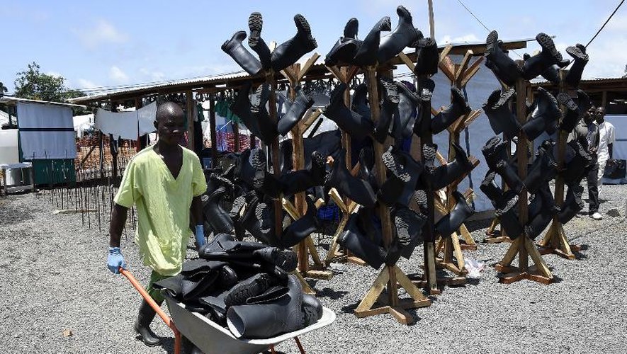 Un homme transporte des bottes désinfectées du personnel médical au centre de Médecins sans frontières à Monrovia, le 27 septembre 2014