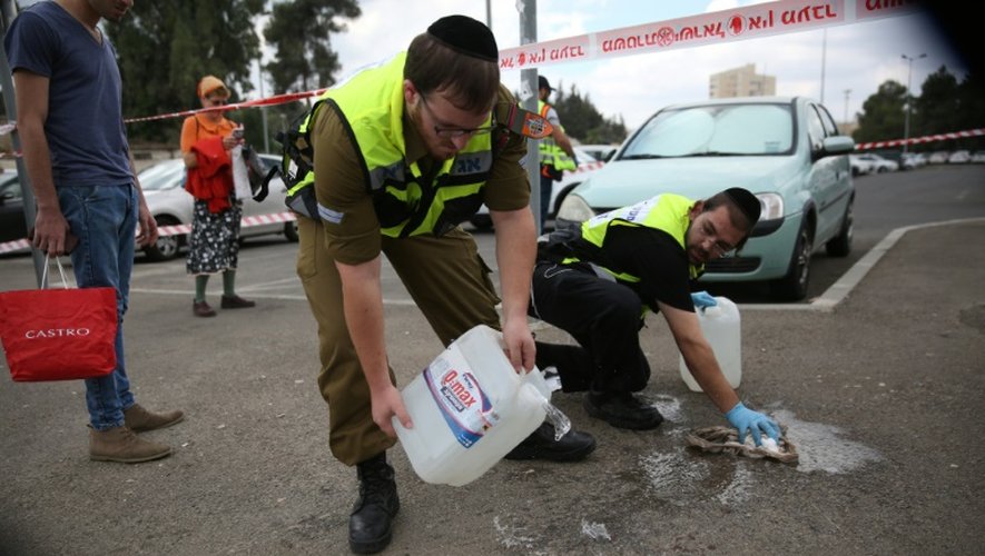 Des enquêteurs israéliens nettoient la scène après l'attaque contre un juif orthodoxe dans la Vieille ville de Jérusalem, le 8 octobre 2015