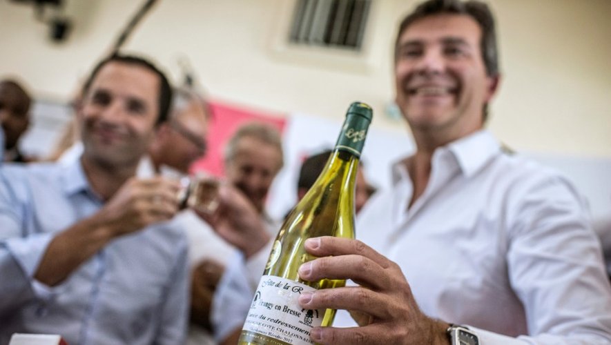 Arnaud Montebourg, alors ministre de l'Economie, goûte la "cuvée du redressement" avec Benoît Hamon, ministre de l'Education, le 24 août 2016 à Frangy-en-Bresse (Saône-et-Loire), à la veille de leur départ du gouvernement