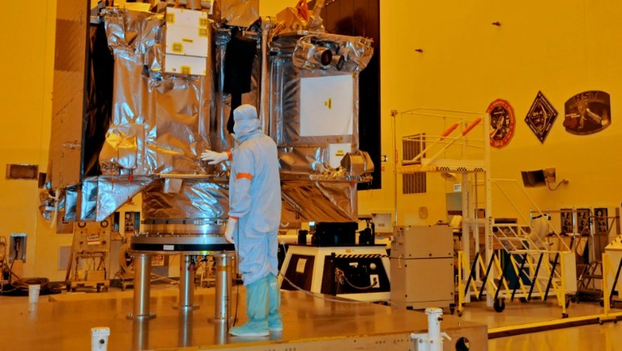 Un ingénieur contrôle la couverture de protection du vaisseau OSIRIS-REx dans un atelier du Centre spatial Kennedy, le 20 août 2016 en Floride