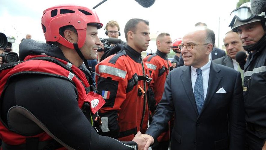 Le ministre de l'Intérieur Bernard Cazeneuve avec des pompiers le 30 septembre 2014 à Maugio près de Montpellier
