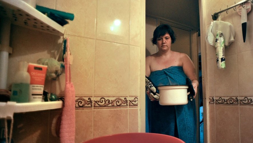 Une femme se prépare à se laver à Saint-Pétersbourg, le 7 juillet 2016 alors que l'eau chaude est traditionnellement coupée en été