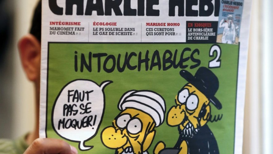 Un homme lit le 19 septembre 2012 le numéro de Charlie Hebdo paru ce jour-là, montrant un juif et un musulman sous le titre "Intouchables 2"