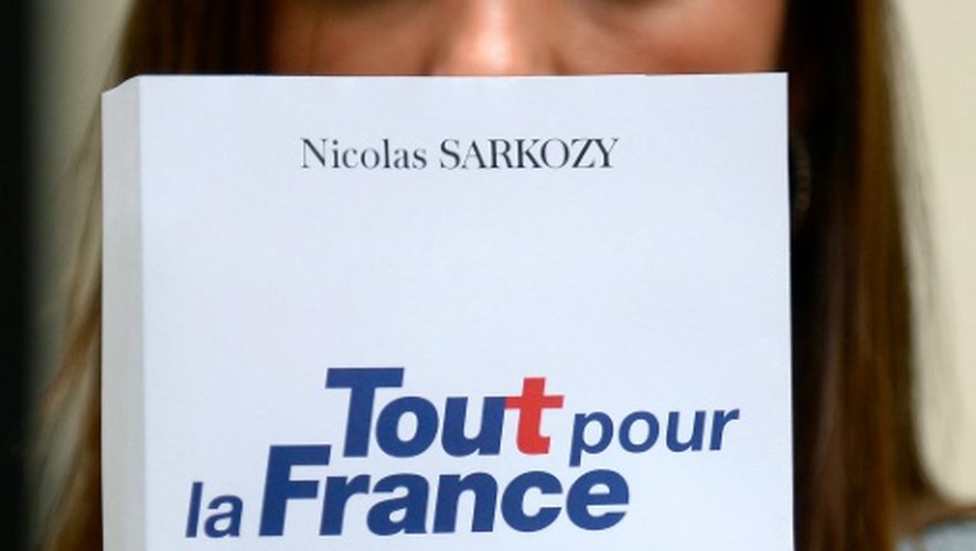 Une femme tient un nouveau livre de Nicolas Sarkozy où il annonce sa candidature à la présidentielle 2017, le 22 août à Paris