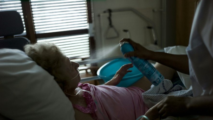 Une infirmière asperge d'eau une personne âgée qui souffre de la chaleur, le 22 juillet 2013 dans un hôpital d'Argenteuil, près de Paris