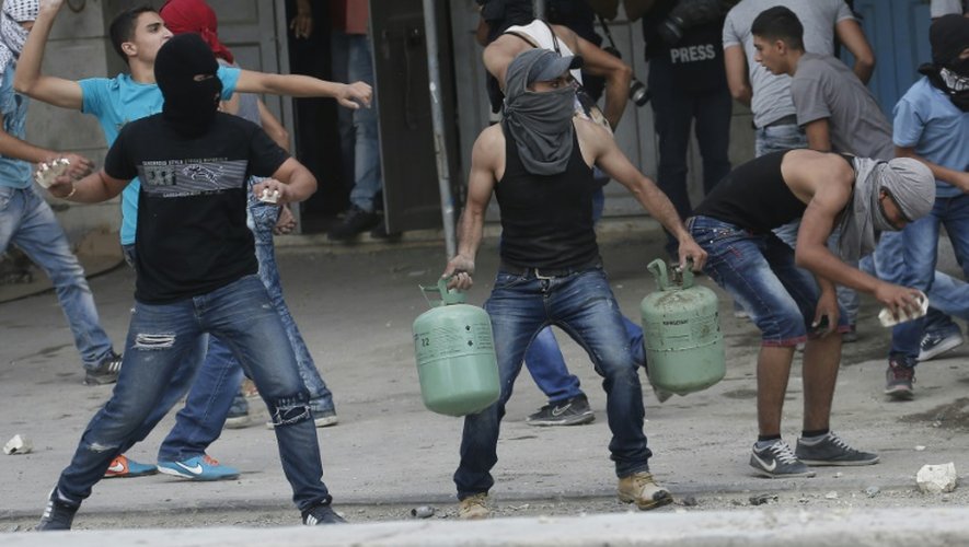 De jeunes palestiniens lancent des pierres contre les forces de sécurité israéliennes au checkpoint de Qalandia entre Jérusalem et Ramallah, le 6 octobre 2015
