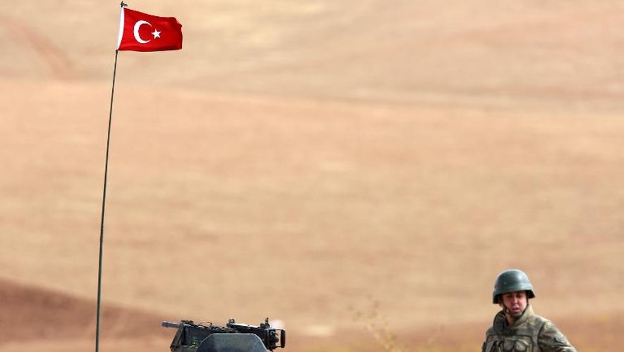 Un militaire turc observe sur une colline les combattants du groupe Etat islamique positionnés à 10km de la ville kurde de Kobané, le 2 octobre 2014
