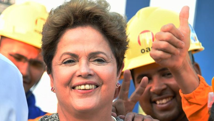 Dilma Rousseff entourée de travailleurs lors d'une visite à l'usine Mare favela le 12 septembre 2014 à Rio de Janeiro