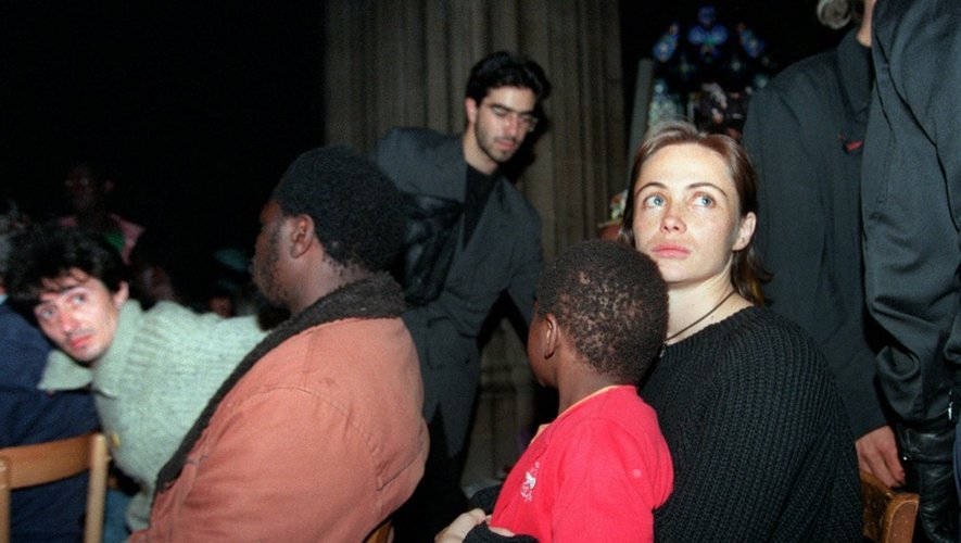 L'actrice Emmanuelle Béart tient un enfant sur ses genoux pendant l'évacuation de l'église Saint-Bernard à Paris, le 23 août 1996