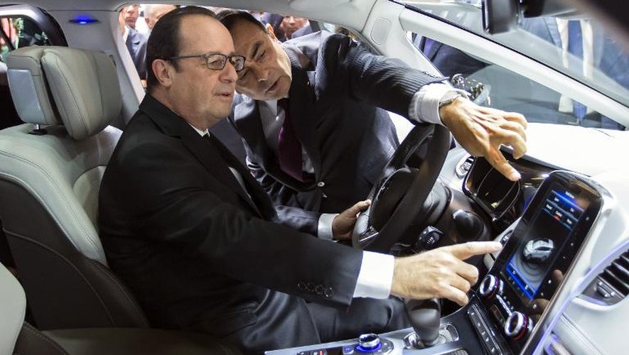 Francois Hollande écoute les explications de Carlos Ghon au volant d'une Renault Espace le 3 octobre 2014 au Mondial de l'auto à Paris