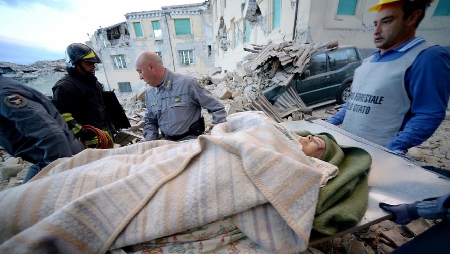 Des sauveteurs transportent un homme à Amatrice, dans le centre de l'Italie, après un fort séisme, le 24 août 2016