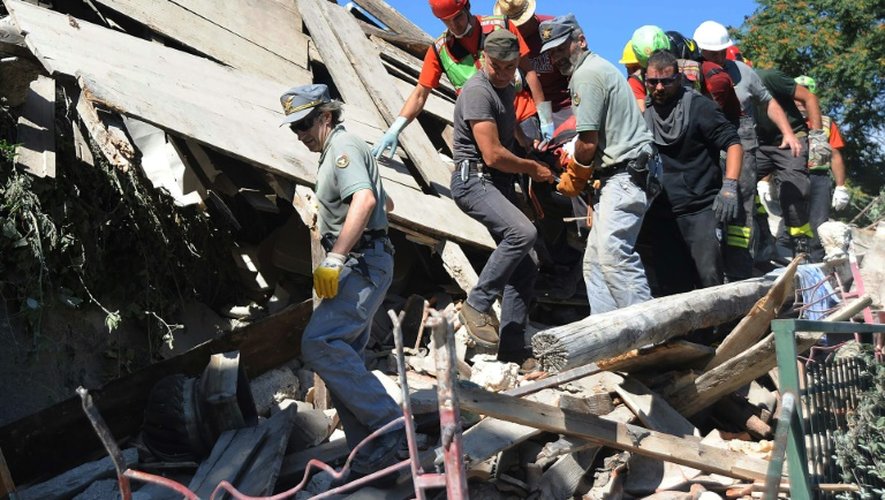 Des secouristes emportent les corps des victimes du séisme à Pescara del Tronto, le 24 août 2016