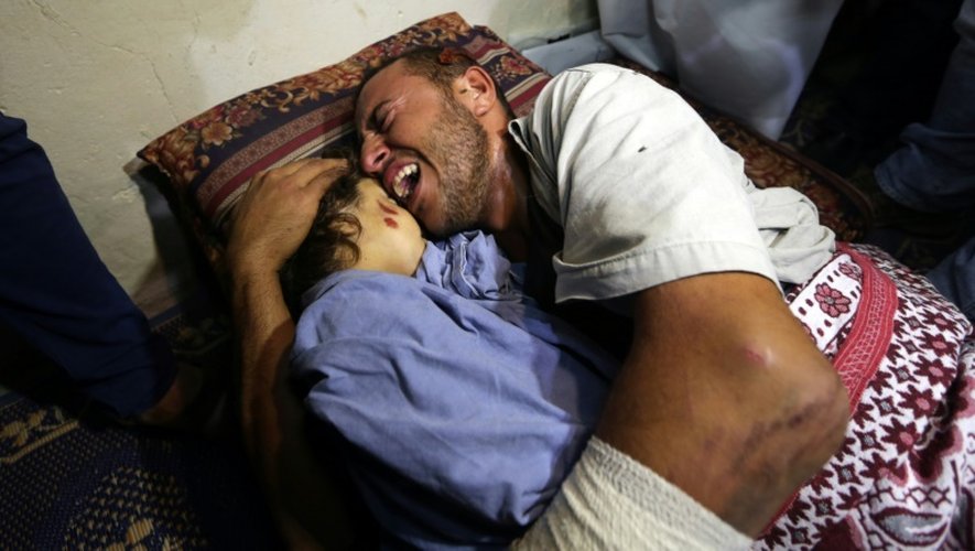 Yehya Hasan étreint le corps de sa fille Rahaf tuée, avec sa mère enceinte, par un raid aérien de l'armée israélienne dans la bande de Gaza, le 11 octobre 2015