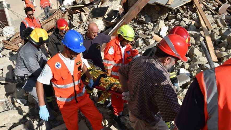 Des sauveteurs sortent un homme des décombres à Arquata del Tronto, dans la région des Marches, le 24 août 2016, après le séisme qui a frappé le centre de l'Italie
