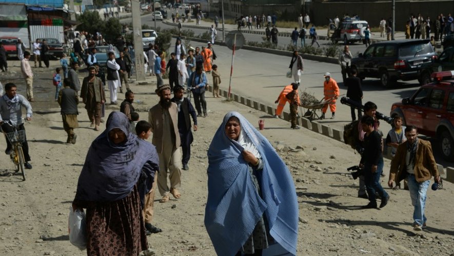 Des personnes passent devant la scène de l'attentat suicide à Kaboul le 11 octobre 2015