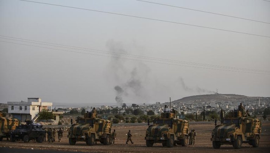 La ville syrienne de Kobané, au loin, alors que l'armée turque prend position, dans la ville de Suruc, à la frontière avec la Syrie, le 3 octobre 2014