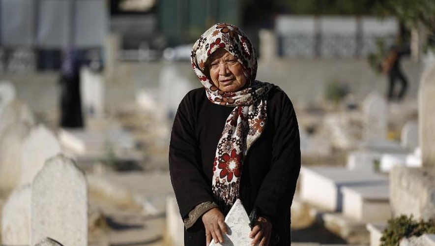 Une Palestinienne prie sur la tombe d'un proche au cimetière de Gaza, le 4 octobre 2014
