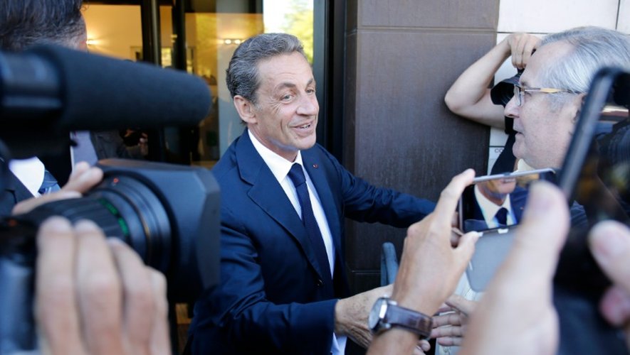Nicolas Sarkozy serre des mains en arrivant à son nouveau QG de campagne à Paris le 23 août 2016