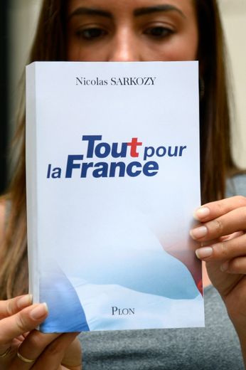 Une femme tient un exemplaire du livre de Nicolas Sarkozy à paraître mercredi, le 22 août 2016 à Paris
