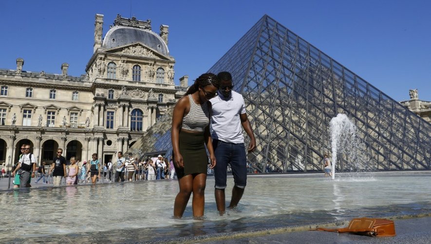 Les touristes qui ont bravé le soleil ont souvent fait trempette dans les fontaines parisiennes, comme ici devant la pyramide du Louvre
