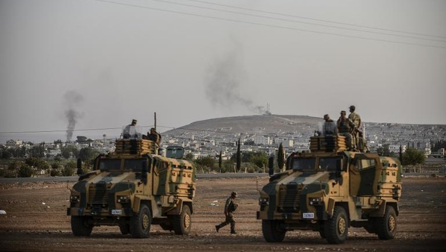 Des forces turques stationnées le 3 octobre 2014 près de la ville de Kobané d'où s'élève de la fumée