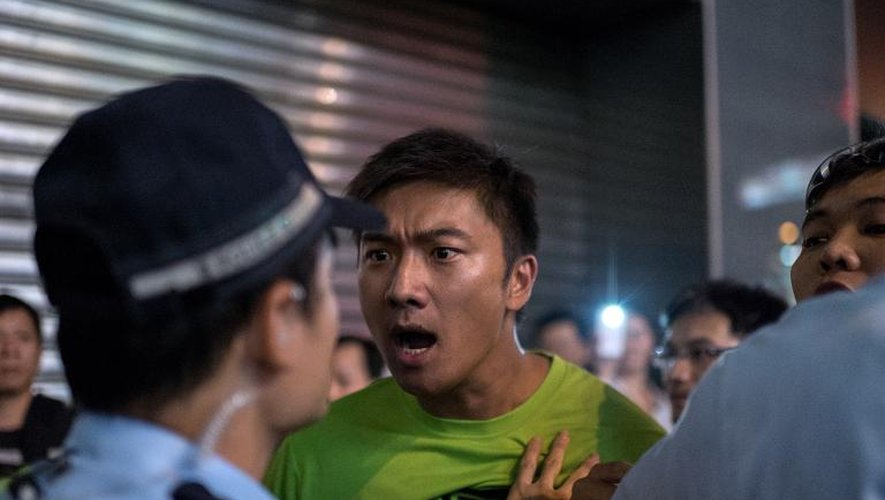 Un manifestant prodémocratie s'en prend à des policiers accusés de passivité le 4 octobre 2014 à Hong Kong