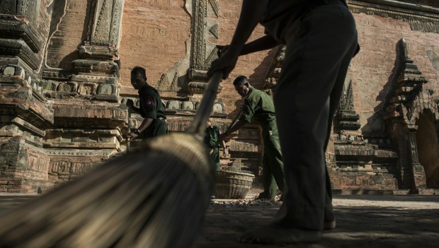 Des soldats pieds nus, comme de coutume  dans les temples bouddhistes, ramassent les débris, le 25 août 2016, dans un temple du sanctuaire de Bagan endommagé la veille par un séisme