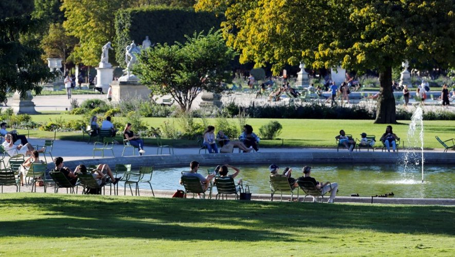 Dans le jardin parisien des Tuileries, pour les promeneurs, la joie d'avoir du beau temps l'emporte sur l'accablement dû à la chaleur
