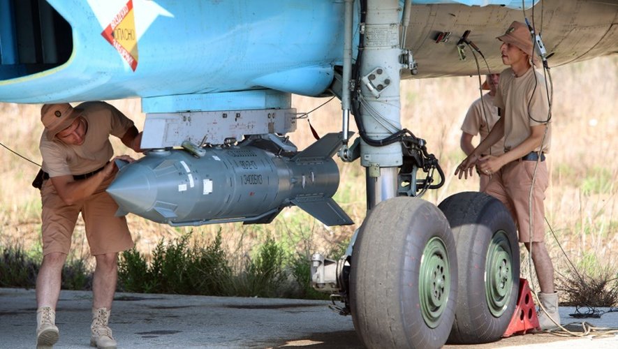 Des mécaniciens russes vérifient les fixations d'une bombe d'un Soukhoï SU-34 sur la base aérienne de Hmeimim, dans la province syrienne de Lattaquié, le 3 octobre 2015