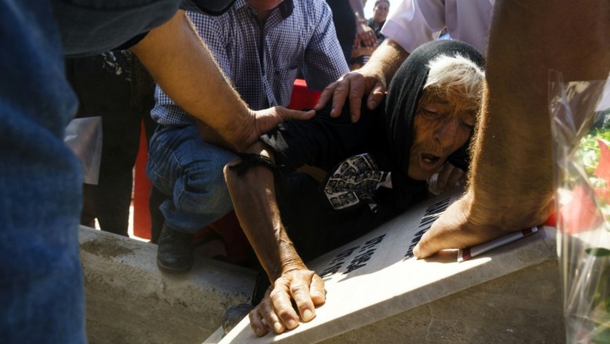 Une Chypriote turque se   lamente sur la tombe d'un proche, disparu lors des affrontements de 1974, lors d'une cérémonie funéraire, le 15 août 2016  dans le village de Tashkent en République turque de Chypre du nord