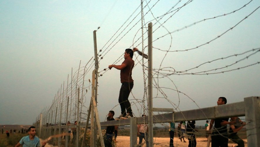 Des Palestiniens s'attaquent aux barbelés à la frontière entre Gaza et Israël, lors d'affrontements avec les forces de l'ordre israéliennes le 12 octobre 2015