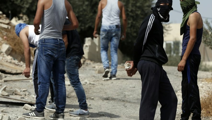 Des jeunes Palestiniens s'apprêtent à affronter des soldats israéliens dans la banlieue de Jérusalem le 12 octobre 2015