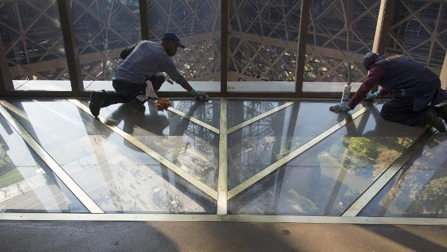Des travailleurs nettoient la plaque de verre du premier étage de la Tour Eiffel, le 6 octobre 2014 à Paris
