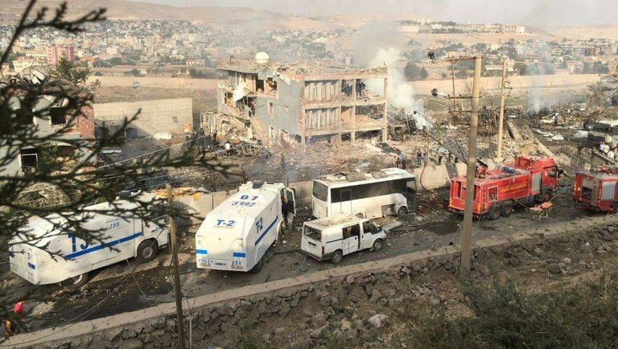 Policiers turcs et pompiers se sont rendus sur le site de l'attaque contre une caserne de police à Cizre (sud-est de la Turquie), le 26 août 2016